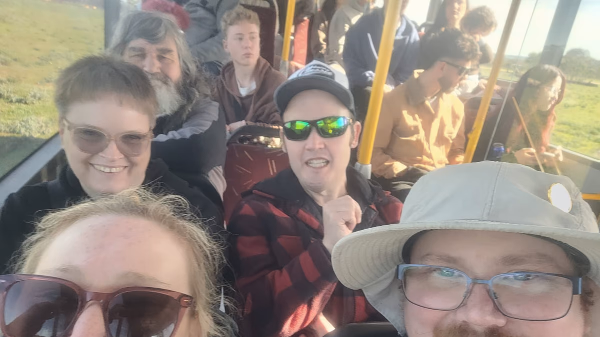 Group members together on a day trip, smiling at the camera