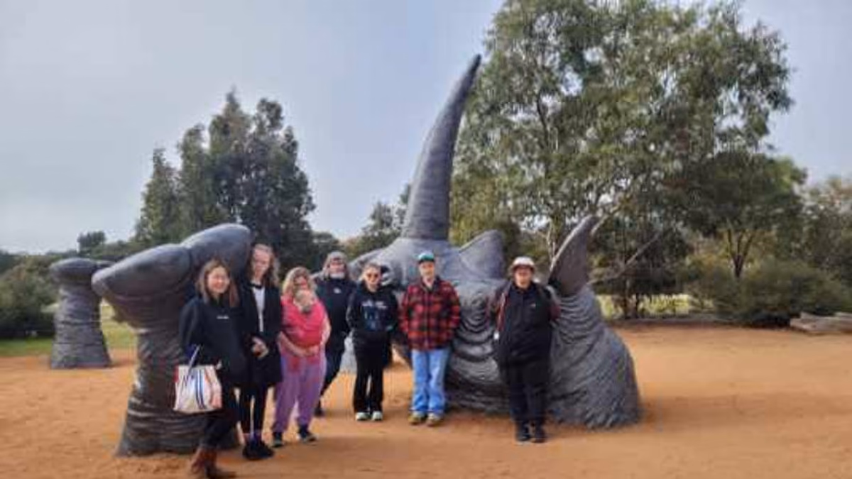 A support worker and participants enjoying an outdoor group excursion together